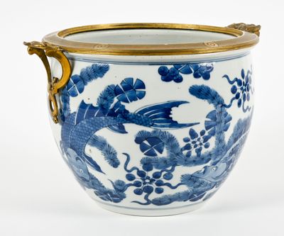 un vase bleu et blanc muni d'une anse dorée