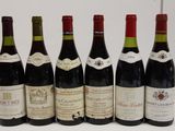 six bottles of wine are lined up in a row on a table