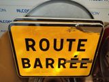 a yellow sign that says route barree on it