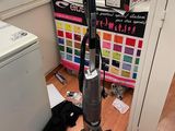 un aspirateur posé par terre à côté d'une machine à laver