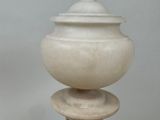 a white vase sitting on top of a wooden table