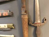many different types of knives on display on the wall