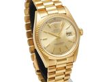 an image of a gold rolex watch on display on a stand