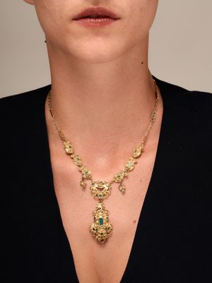 une femme portant un t-shirt noir et un collier en or