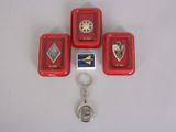 four red trays with badges and a keychain on a white surface