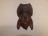 une sculpture en bois représentant un homme coiffé d'un chapeau