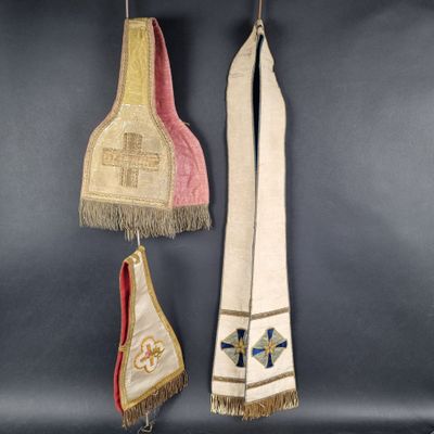 three pieces of cloth hanging from hooks on a wall