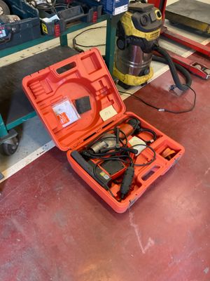 une boîte à outils rouge contenant des outils, posée par terre