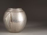 a silver vase that is sitting on a table