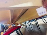 a person that is holding a piece of wood under a table