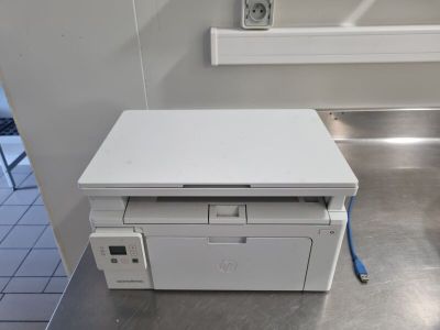 une imprimante blanche posée par terre dans une pièce
