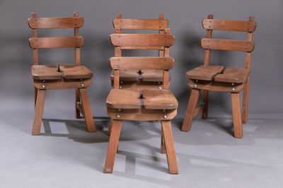 trois chaises en bois placées les unes à côté des autres sur une surface grise