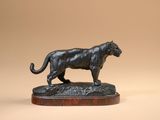 a bronze statue of a panther on a wooden base
