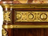 a gold and red marble top on a wooden cabinet