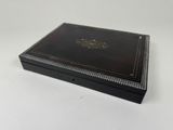 a black box with a gold emblem on it sitting on a white surface