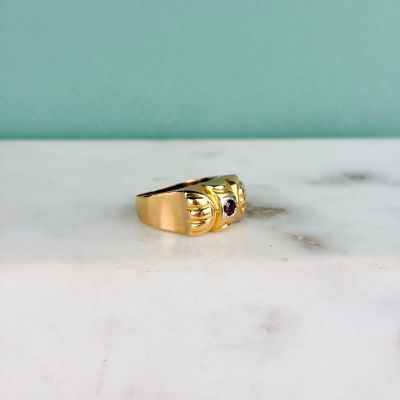 une photo d'une bague en or sertie d'un grenat
