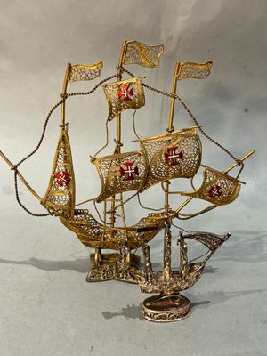 maquette en laiton d'un voilier arborant une croix rouge sur ses voiles
