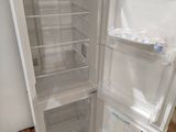 a white refrigerator with its door open in a room