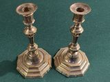 deux bougeoirs en argent posés sur une table verte