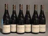 six bouteilles de vin sont alignées sur une table