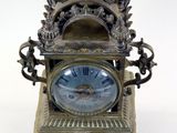 a clock that is sitting on a stand on a white surface