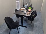 a room with a table, chairs, and a microwave in it