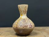 un petit vase posé sur une table en bois