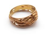 une image d'un gros plan d'une bague en or sur une surface blanche