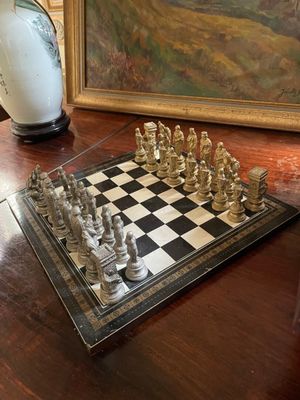 un échiquier posé sur la table, à côté d'un tableau