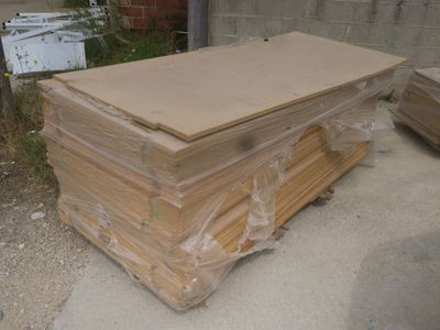 un tas de cartons posé par terre à côté d'un immeuble