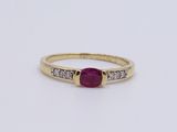 a yellow gold ring with a ruby stone and diamonds