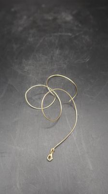 a close up of a pair of gold earrings on a table