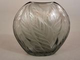 a clear glass vase with a leaf design on it