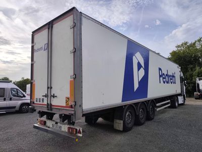 un camion qui est garé sur un terrain avec d'autres camions