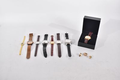 trois montres et une bague en or sont posées sur une table