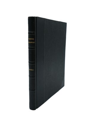 un livre noir orné de lettres dorées, posé sur une surface blanche