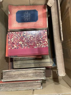 Plusieurs livres sont empilés les uns sur les autres dans une boîte en carton
