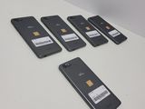 five cell phones are lined up on a white table