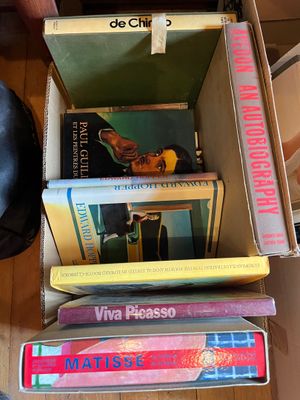 une boîte pleine de livres posée sur le sol