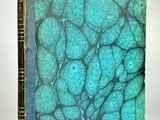 un vieux livre posé sur une surface blanche, avec une couverture bleue