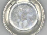 a silver plate that has a picture of a man on it