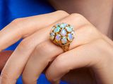 woman in blue shirt holding a ring with oplites on it