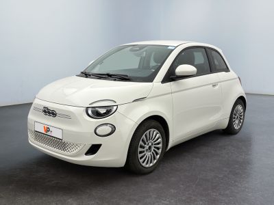 La petite voiture blanche est garée dans une pièce au sol noir.