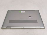 a silver laptop with a green sticker on the back of it