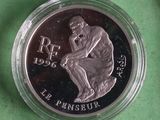 un gros plan d'une pièce de monnaie dans un récipient en verre posé sur une surface verte