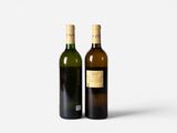 two bottles of wine sitting next to each other on a white surface
