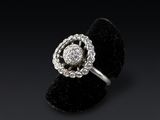 a white gold and diamond flower ring on a black velvet ring holder