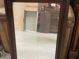 a man standing next to a mirror in a room