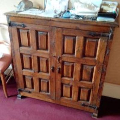 a wooden cabinet with a mirror on top of it