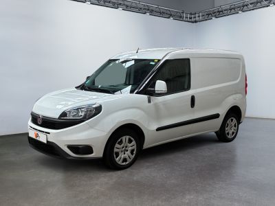 La camionnette blanche est garée dans une grande pièce aux murs blancs